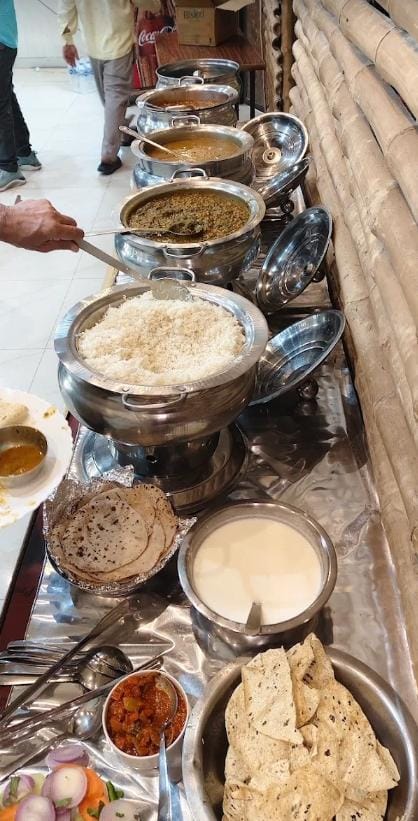 Buffet counter with curries, rice, rotis and papad